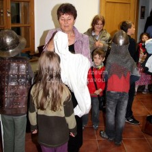 Paní průvodkyně Marie Šikulová pomáhá návštěvníkům do kostýmů. Foto: Antonín Zeman