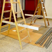 Praktická konstrukce k natírání kovových tyčí od prosklených vitrín. Foto: Kamila Dvořáková