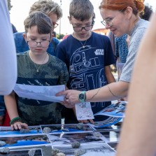 Mladí muži přemýšlí nad starými fotografiemi. Foto: Milan Šustr
